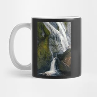 A beautiful waterfall cascades down a mountain in Ireland. Mug